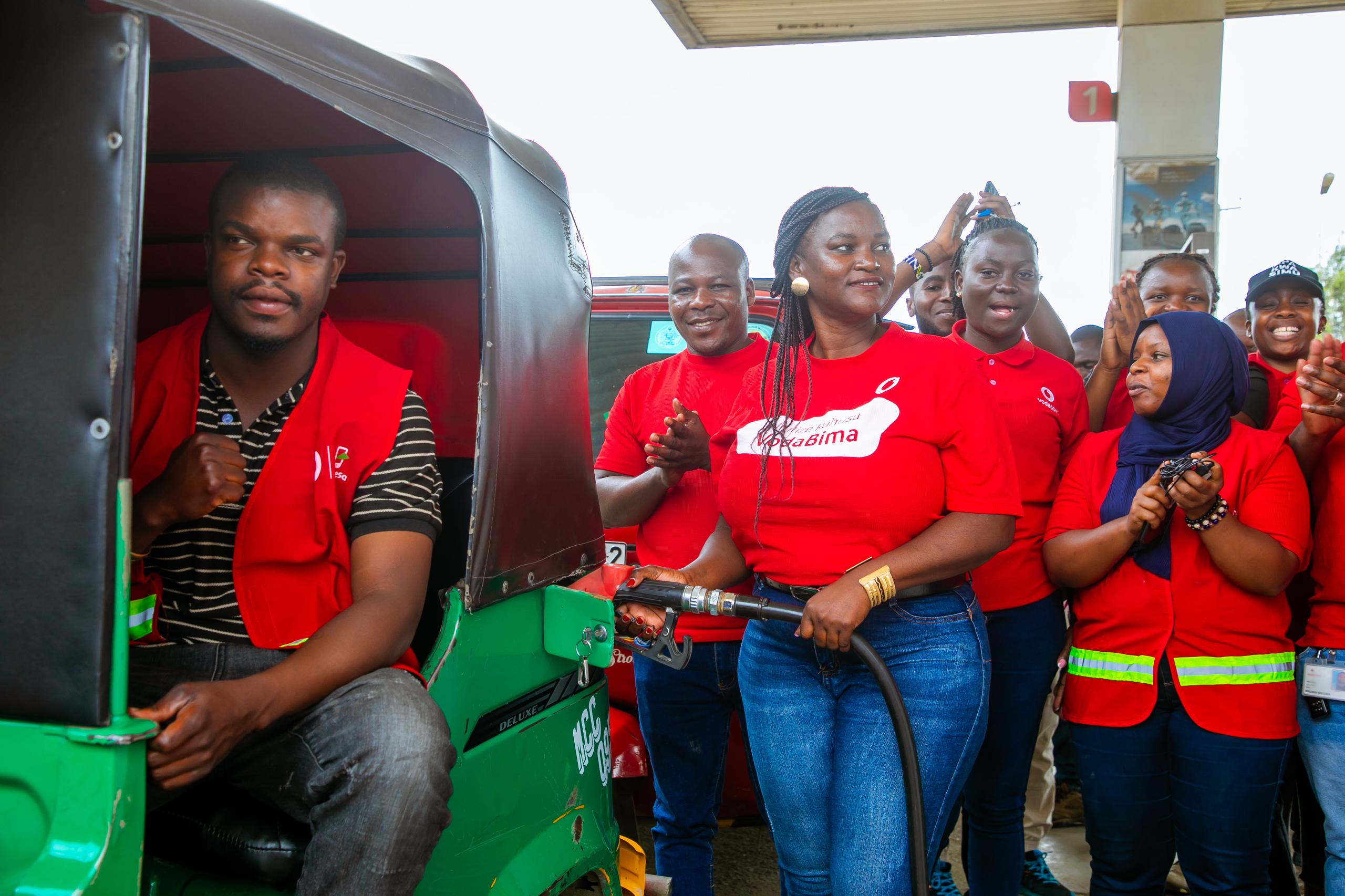 Evelyne Mwinuka, M-Pesa Sales Manager for Vodacom Tanzania's Southern Highlands Zone, fuels Emmanuel Jacob's Bajaj with complimentary fuel as part of the "Shangwe Popote Ukiwa na M-Pesa!" festive campaign, aimed at appreciating customers.