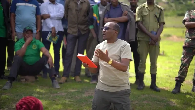 Singida District Commissioner Godwin Gondwe kneels before villagers in Msikii and Munkhola, urging them to vacate Munkhola Forest Reserve.