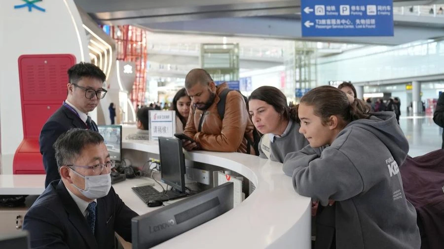 Staff members provide consultation services to passengers from Spain at a service center in Beijing Capital International Airport in Beijing, capital of China, Jan 8, 2025.