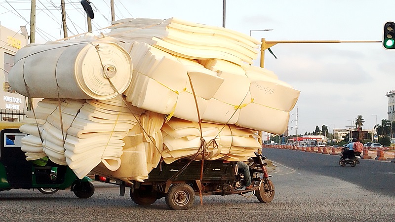 A three-wheeled rider carries pieces of mattress at Bagamoyo-ITV roads intersection in Dar es Salaam yesterday. The luggage hinders his rear view which is against road safety regulations. 