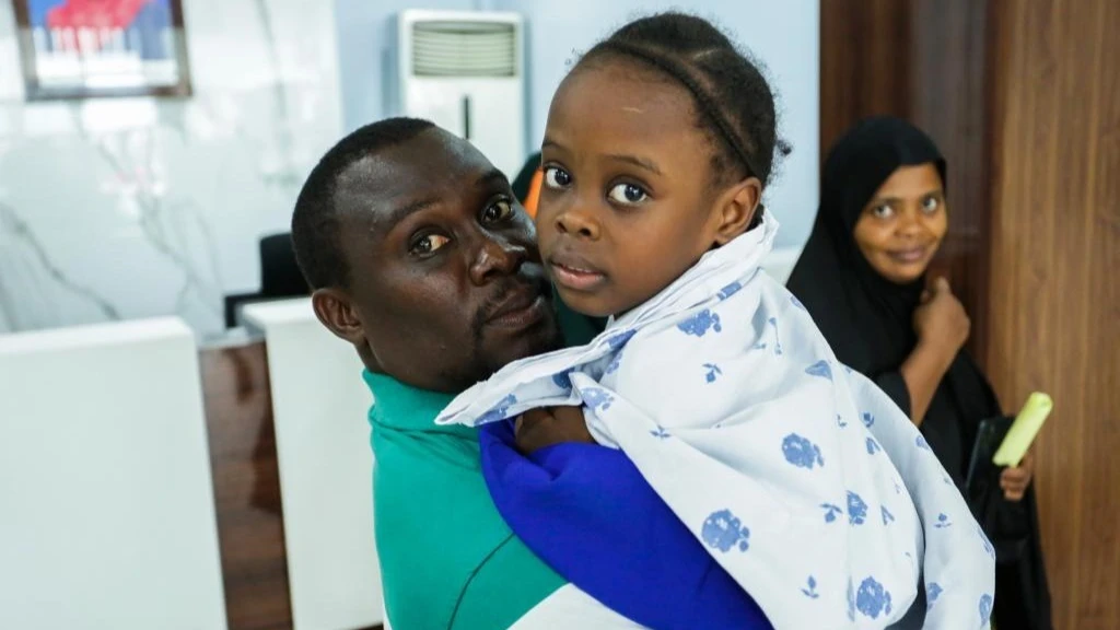 A young Tanzanian father holds his daughter before her heart surgery at Jakaya Kikwete Cardiac Institute in Dar es Salaam.