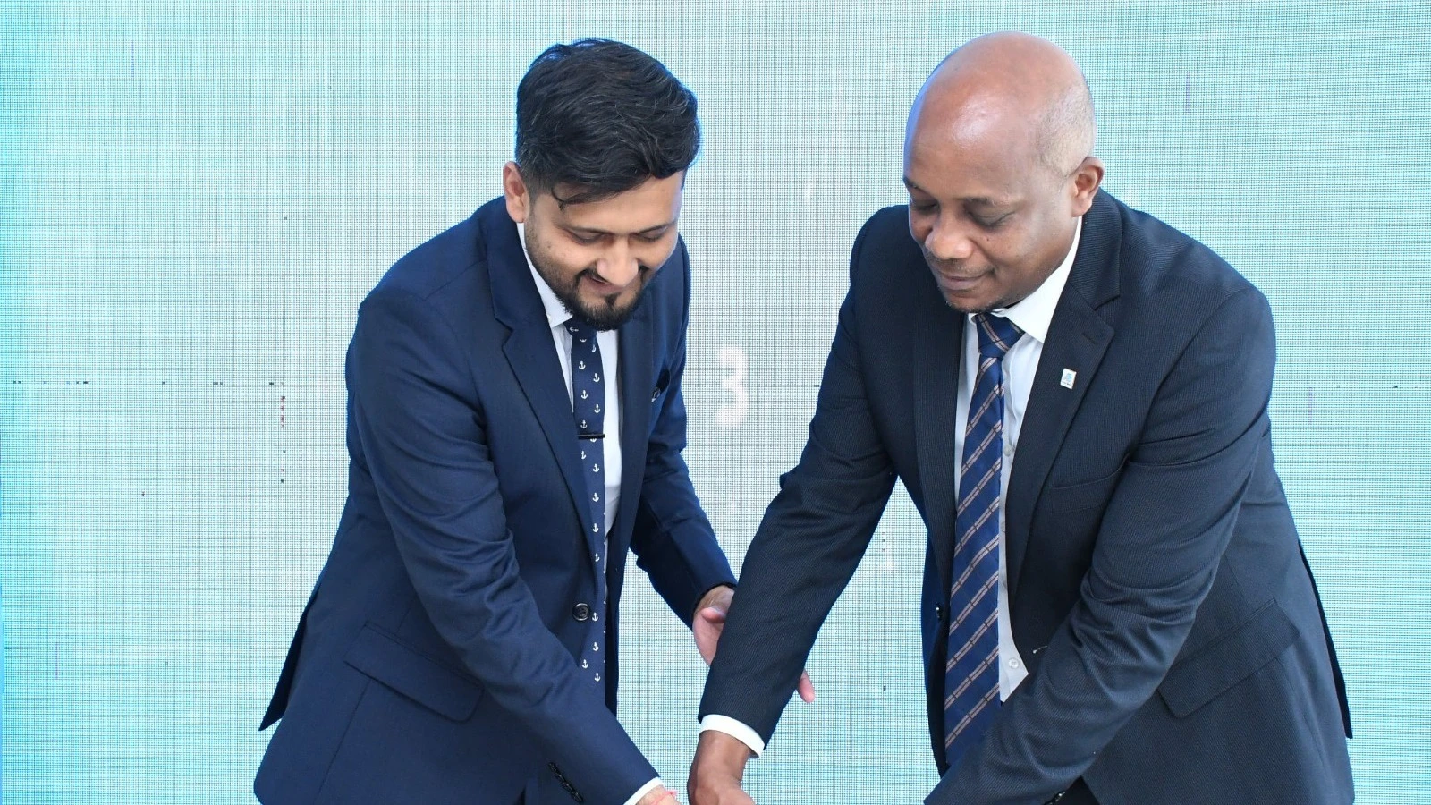 Senior Manager for Personal Customer Services at Azania Bank, Mr. Jackson Lohay, and the Head of Digital Banking at Azania Bank, Mr. Vinesh Davda, celebrated after officially launching the bank's new digital banking services. 