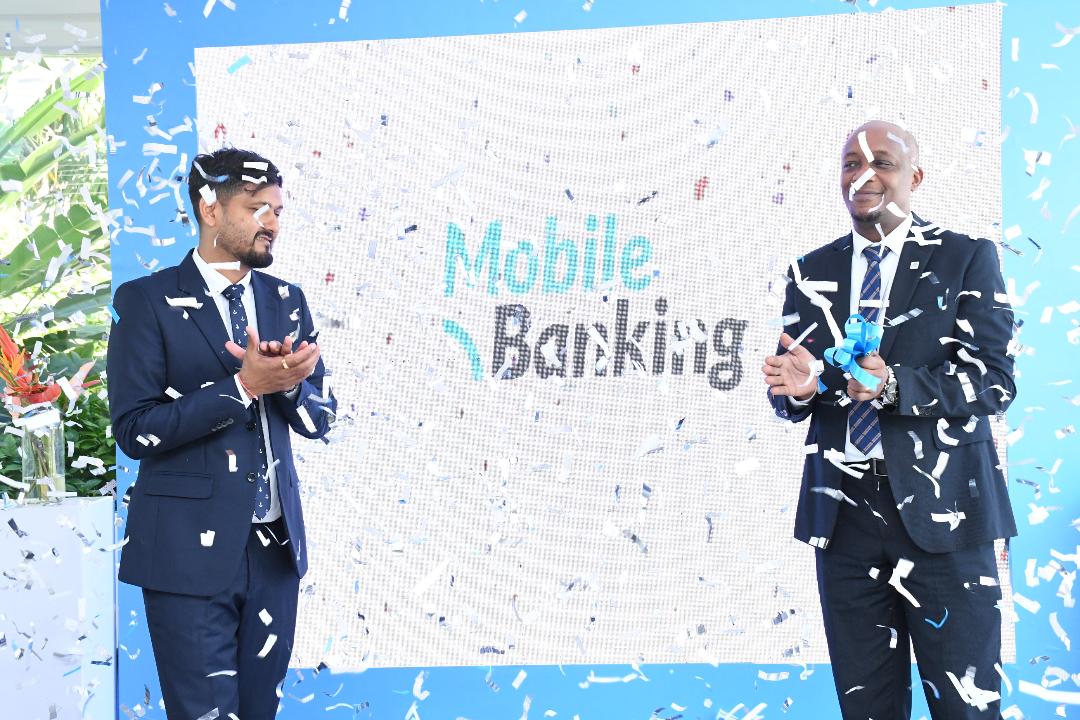 Azania Bank Limited senior retail manager Jackson Lohay (R) and head of digital banking Vinesh Davda in jovial mood in Dar es Salaam yesterday shortly after the launch of the bank’s integrated – mobile, online, agency and WhatsApp banking services 