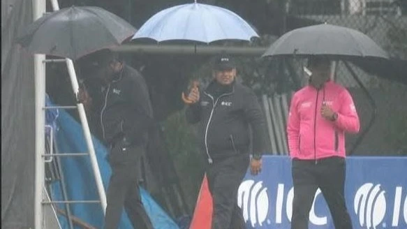 Match officials in the 2025 ICC Men's Cricket World Cup Challenge League B are pictured on Wednesday leaving the pitch at the Mission Road ground in Mong Kok as the clash between Tanzania and Hong Kong was abandoned because of rain. 