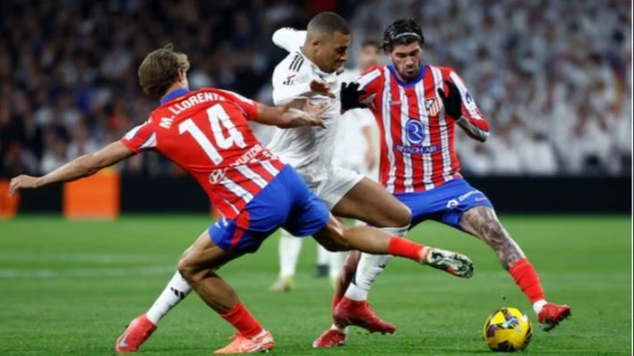 Real Madrid's Kylian Mbappe in action with Atletico Madrid's Marcos Llorente and Rodrigo De Paul during their LaLiga match at Santiago Bernabeu, in Madrid, Spain on February 8, 2025.