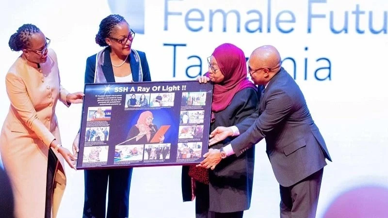 President Samia Suluhu Hassan receives a gift in Dar es Salaam yesterday from a representative of participants of the just-completed 10th Female Future Programme.