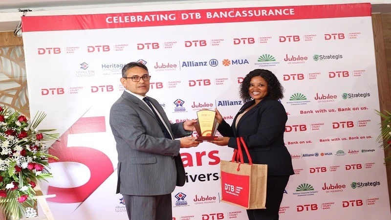 Chief guest, Tanzania Insurance Regulatory Authority (TIRA) Quality and Risk Management Officer, Victoria Mwavilenga receives an award from DTB Chief Executive Officer, Ravneet Chowdhury given to TIRA CEO, Dr Baghayo Saqware .