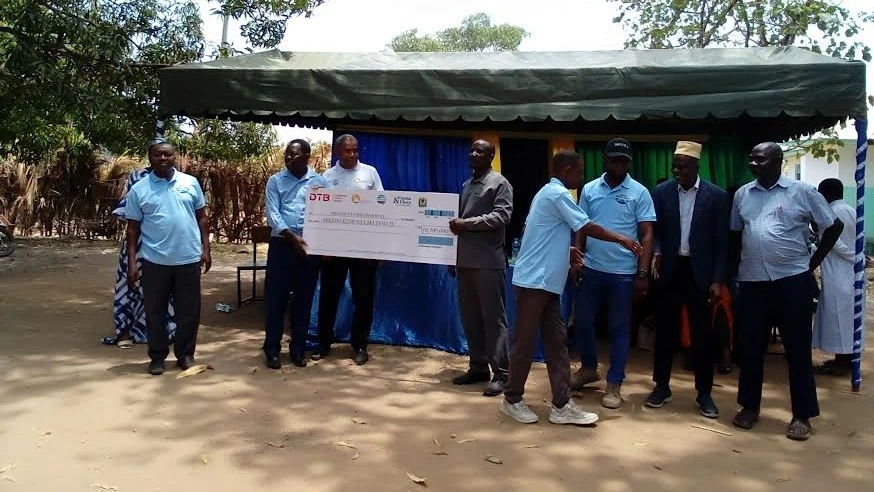 Mratibu wa Shirika la Mwambao Coastal Community Network Tanzania, Ahmed Salim (wapili kushoto), akikabidhi fedha kwa wanachama wa vikundi vitano 