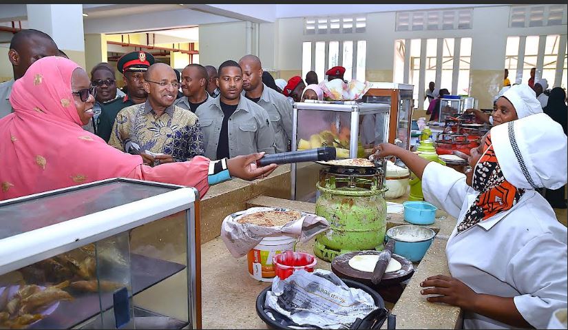 President of Zanzibar and Chairman of the Revolu-tionary Council, Dr. Hussein Ali Mwinyi, speaks with street food vendors (Mama Lishe) at Jumbi Market in Magharibi "B" District, Unguja, during his visit to as-sess the business environment.