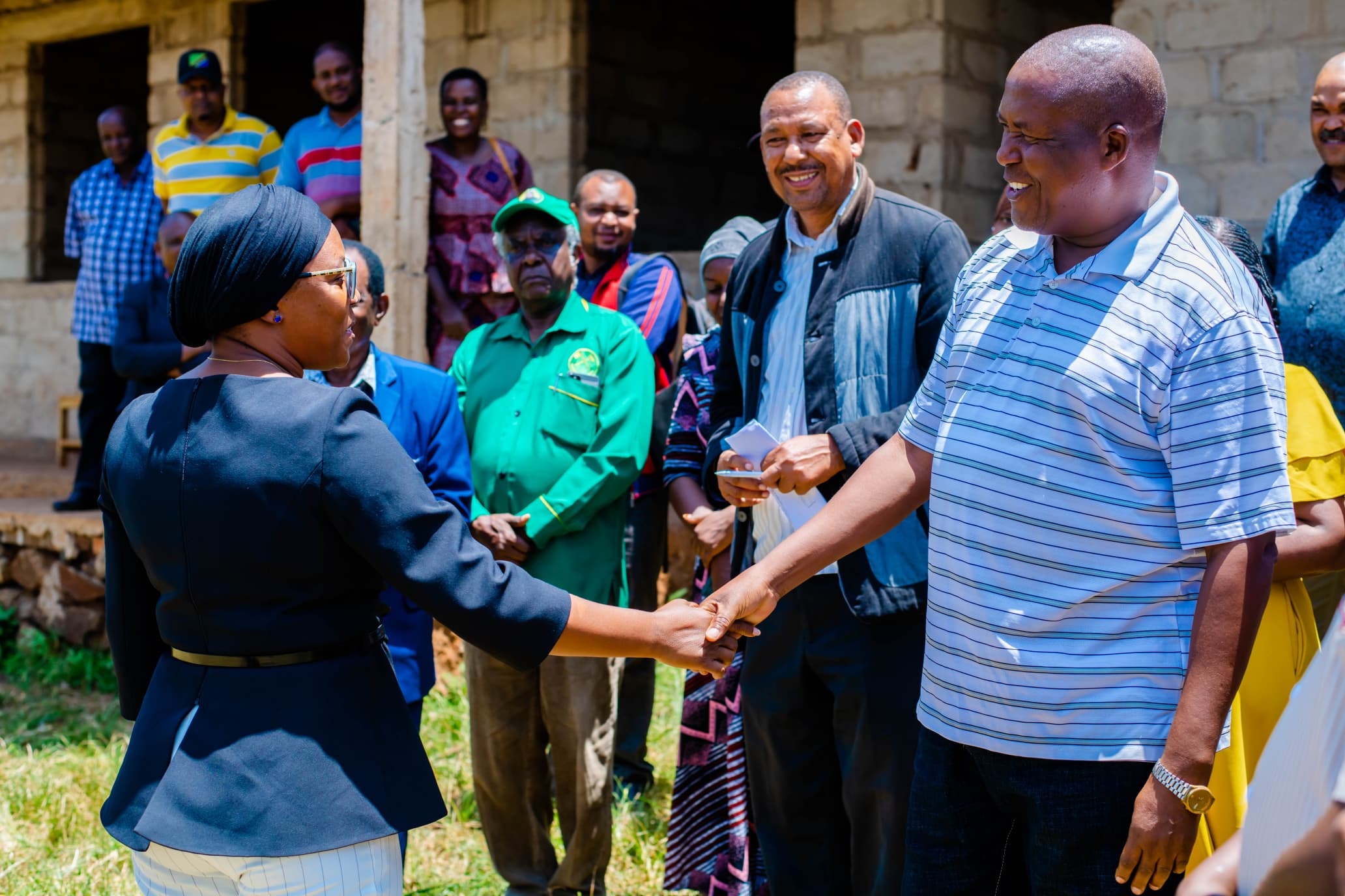 Manyara Regional Commissioner, Queen Sendiga (L), exchanges greetings Bagara Ward councillor, Yona Sulle, yesterday during her visit to Komoto Secondary School in Babati Municipal Council to inspect the construction of the administration block.