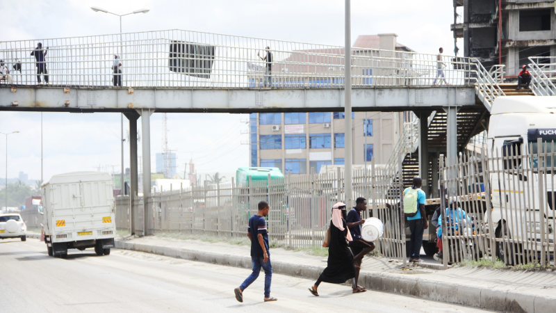 Watembea kwa miguu wakivuka katika eneo lisilo rasmi, badala ya kutumia daraja la juu lililojengwa maalum kwaajili yao katika barabara ya Mandela, eneo la Buguruni,  jijini Dar es Salaam leo, kitendo ambacho ni hatari kwa usalama wao. 