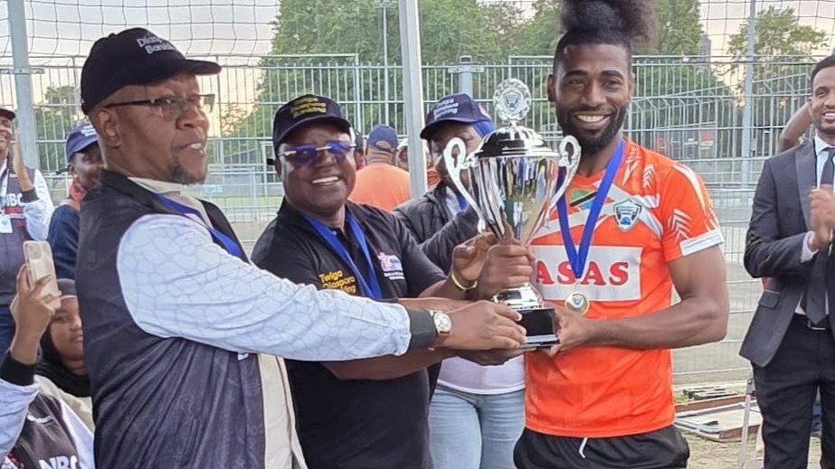 Balozi wa Tanzania nchini Sweden, Mobhare Matinyi (kushoto) na Balozi wa Tanzania nchini Ubelgiji, Jestas Nyamanga, wakimkabidhi kombe la ubingwa wa Bonanza la Serengeti nahodha wa timu ya Kilimanjaro kutoka Sweden, Abbas Bachu.