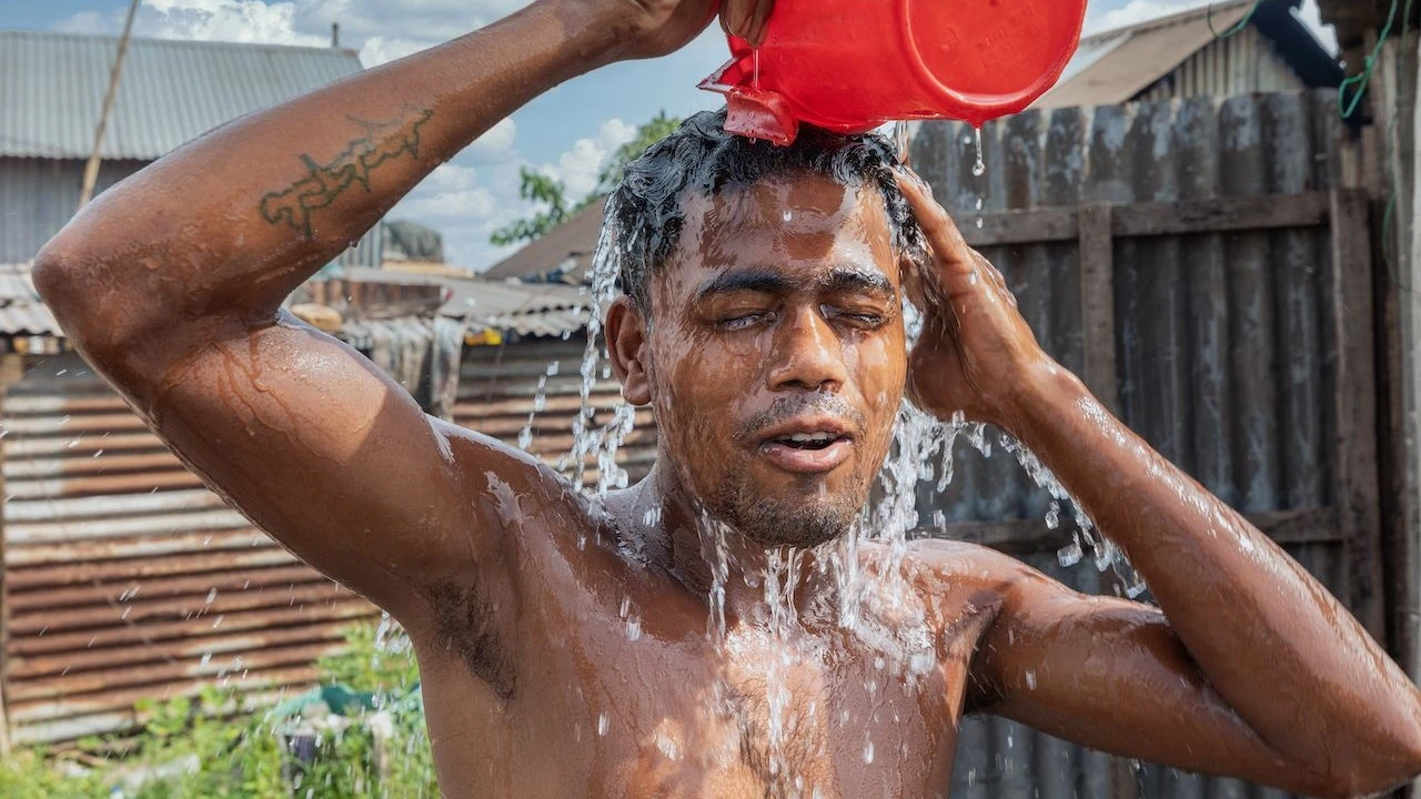 Kijana akifurahia kujimwagia maji mengi