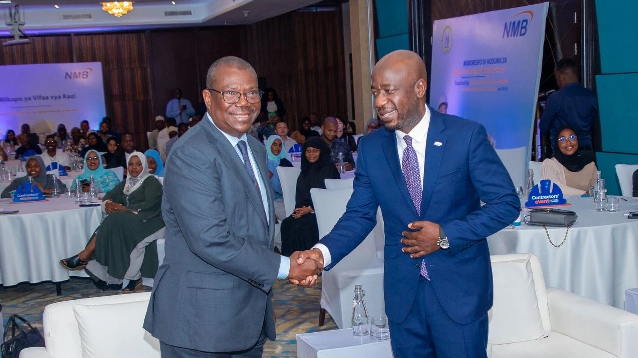 Zanzibar Minister for Construction and Transport, Dr. Khalid Salum Mohammed, congratulating NMB Bank’s Chief Retail and Business Banking Officer, Filbert Mponzi, after the launch of improved financial services for contractors in Zanzibar. 