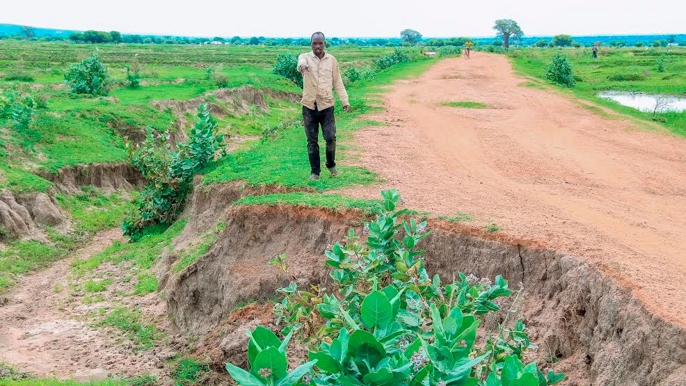 Mwananchi Kulwa Kashinje, mkazi wa Kijiji cha Butini Kata ya Itwangi wilayani Shinyanga, akionesha ubovu wa barabara ambayo imekatwa na maji