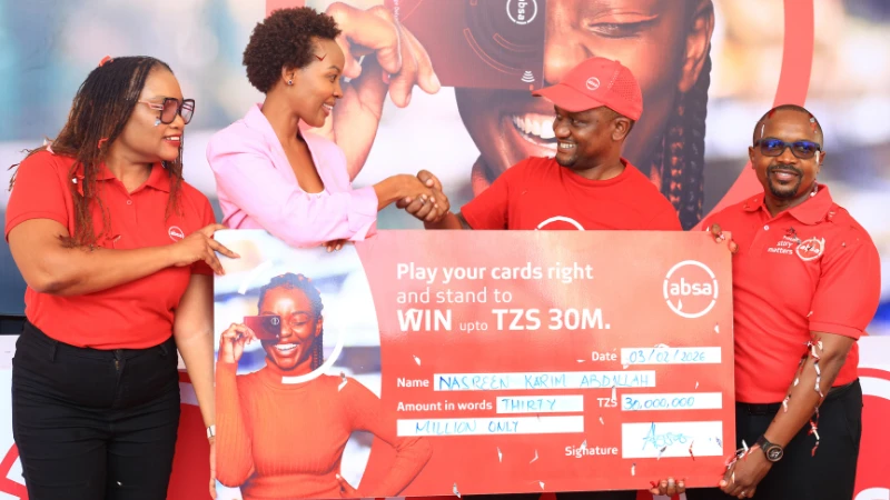 
The Managing Director of Absa Bank Tanzania, Obedi Laiser (2nd R, hands over a dummy cheque worth 30m/- to the grand draw winner of the bank’s ‘Play your cards right’ campaign, Nasreen Karim Abdallah (2nd L), during an event held in Dar es Salaam