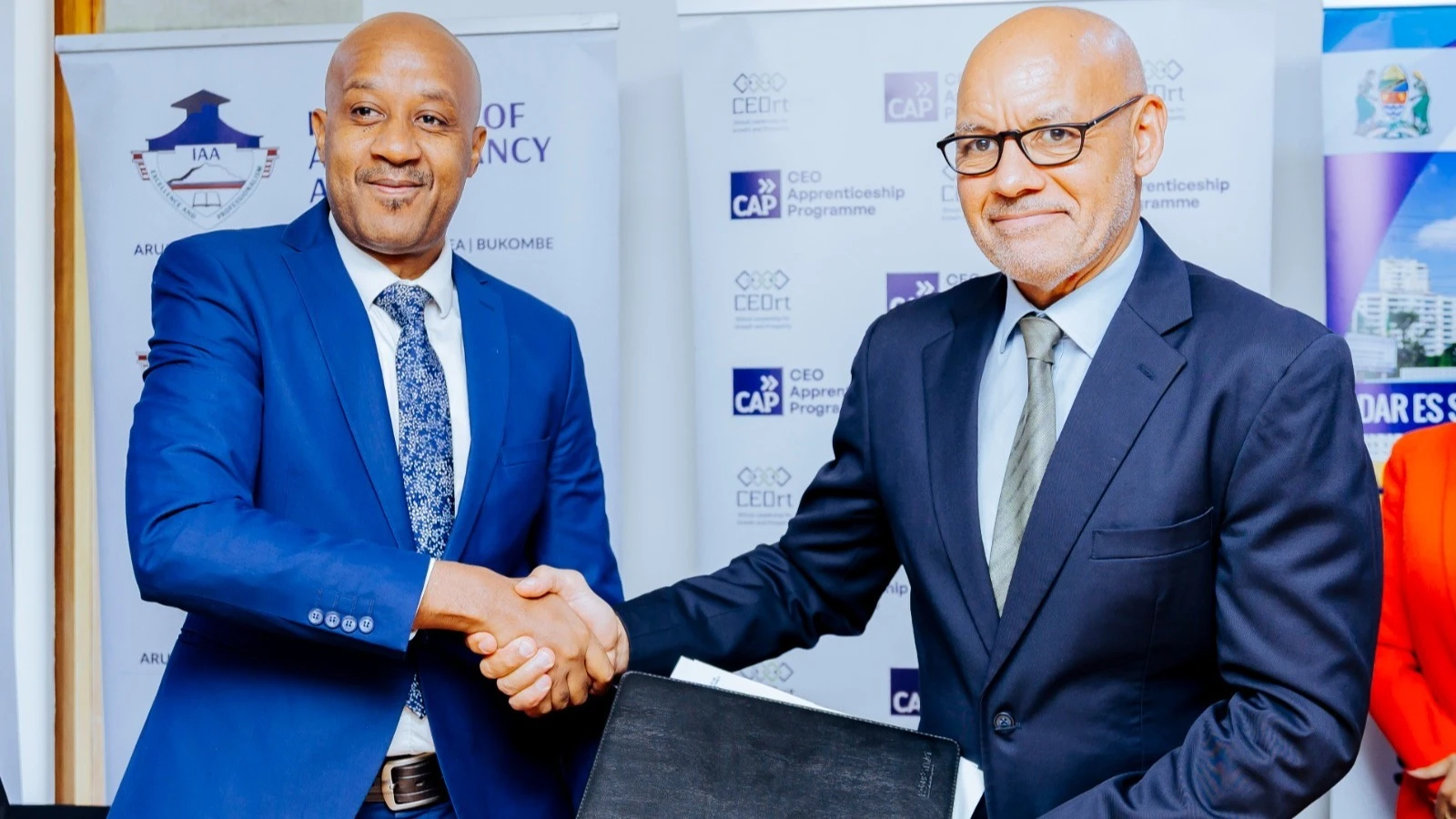 CEOrt- Roundtable of Tanzania Chairman, David Tarimo (R) shakes hand with the Principal of the Institute of Accountancy Arusha (IAA), Prof. Eliamani Sedoyeka (L), after signing a Memorandum of Understanding (MoU)
