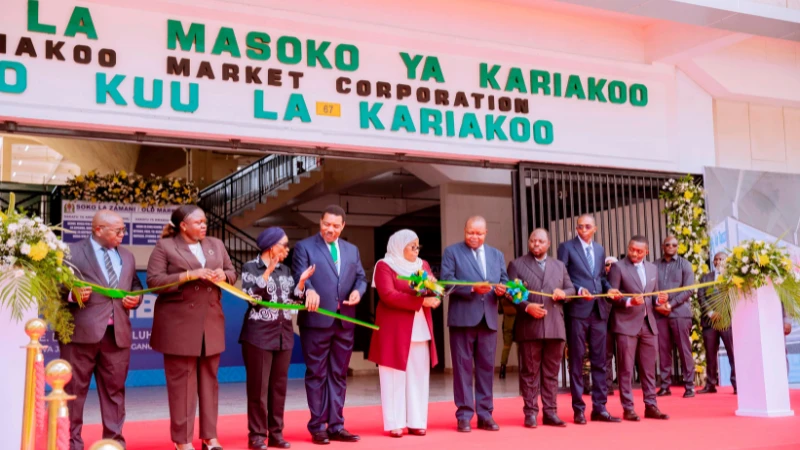 President Samia Suluhu Hassan cuts the ribbon to inaugurate the new Kariakoo Central Market in Dar es Salaam yesterday. Fourth (L) is Prime Minister Dr. Mwigulu Nchemba. 