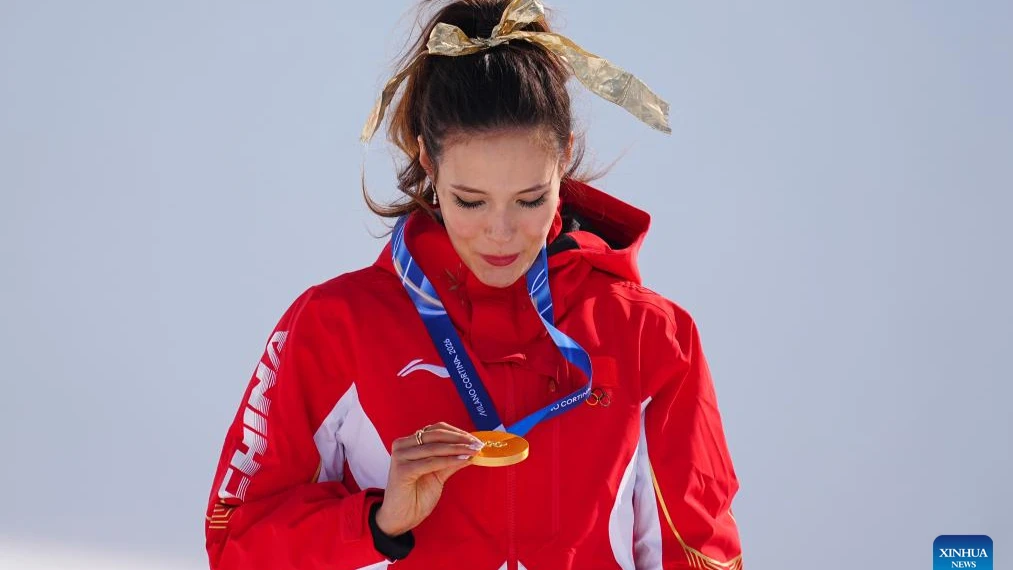 Gold medalist Gu Ailing of China looks at her medal during the awarding ceremony for freestyle skiing women's freeski halfpipe at the Milan-Cortina 2026 Olympic Winter Games in Livigno, Italy, Feb. 22, 2026.