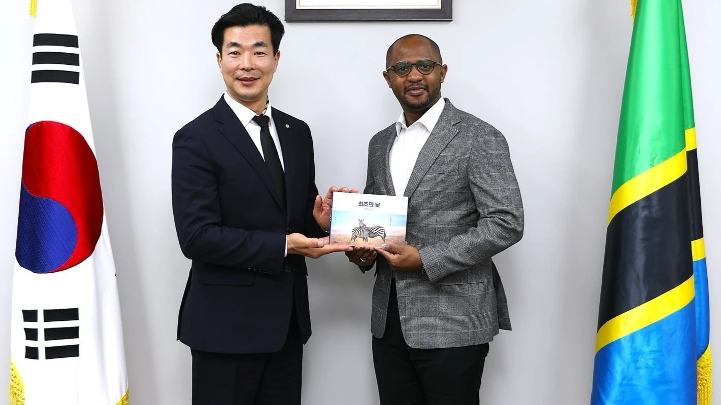 Taegyun Kim, President of the Korean Community in Tanzania (1st L) and Tanzania Ambassador to the Republic of Korea, Togolani Mavura displaying a book—The First Day ( African Proverbs) after it was launched at the Tanzania Embassy in Seoul. 

 