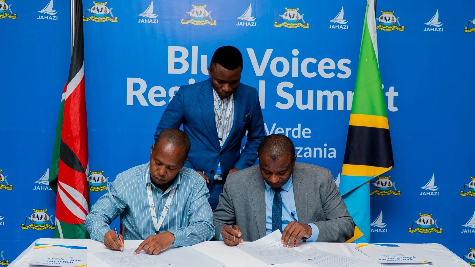 Dr. Paul Sagwe Orina (KMFRI) and Dr. Salim Mohamed Hamza of Zanzibar’s Ministry of Blue Economy and Fisheries sign a cooperation pact at the Blue Voices Summit in Zanzibar, witnessed by The Jahazi Project spokesperson Michael Mallya.
